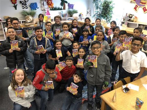 Picture of students holding the book of the month  